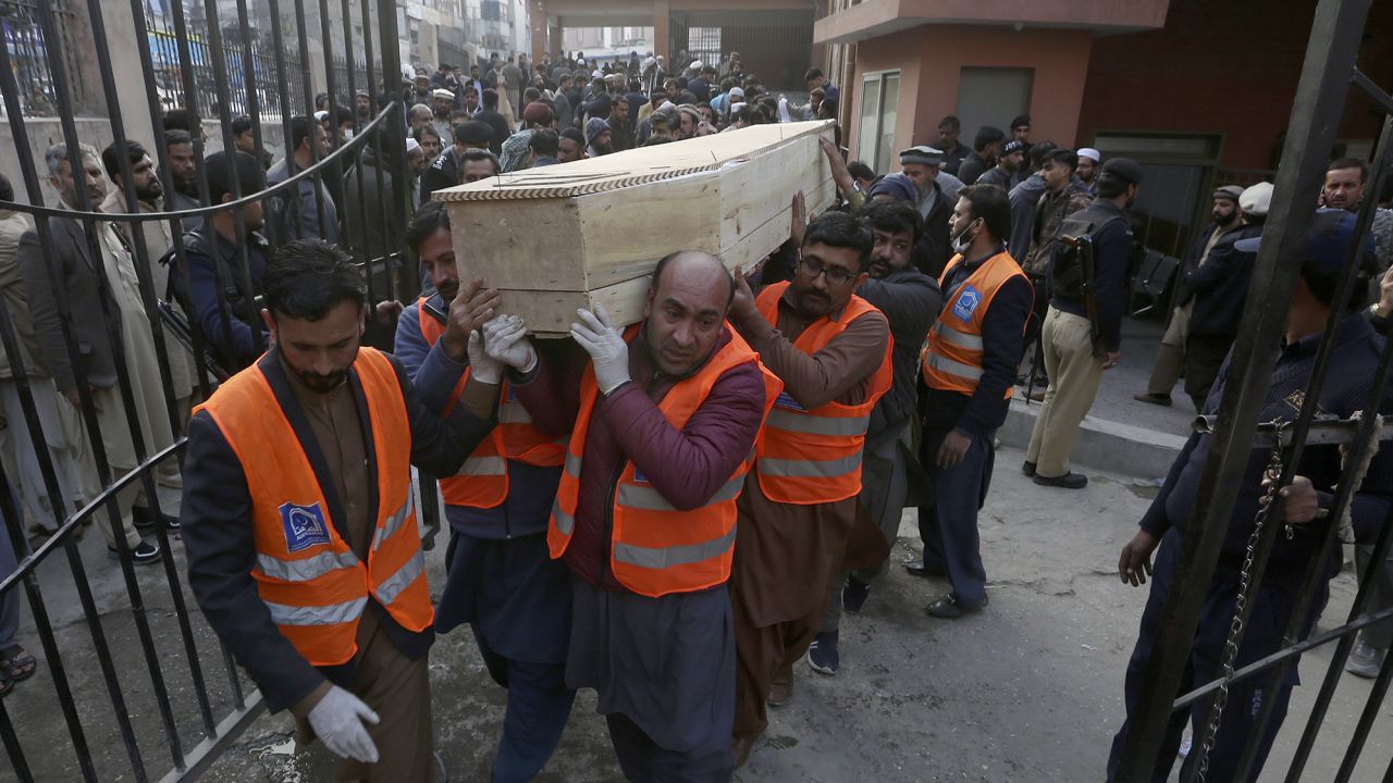 Volunteers carry the coffin of a man killed in the suicide bombing in Peshawar on Monday.
