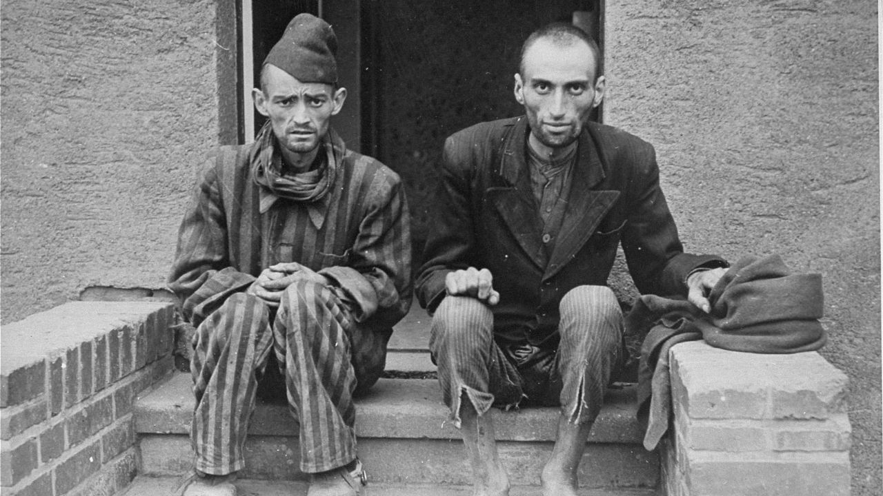 Two Holocaust survivors sit outside the barracks of the newly liberated Nordhausen concentration camp at the end of war.