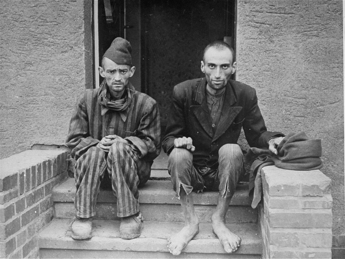 Two Holocaust survivors sit outside the barracks of the newly liberated Nordhausen concentration camp at the end of war.