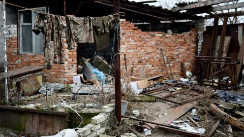 Camoflage terlihat tergantung pada garis di reruntuhan bangunan di desa Zarichne, Ukraina timur.
