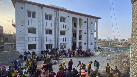 Security officers and rescue workers search for bodies at the scene of a suicide bombing.