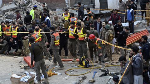 Security officials and rescue workers gather at the site of a suspected suicide bombing, in Peshawar, Pakistan, January 30, 2023. 