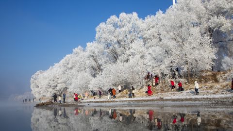 Tourists enjoy rime-covered trees along the Songhua River on January 30, 2023 in China's Jilin province. 