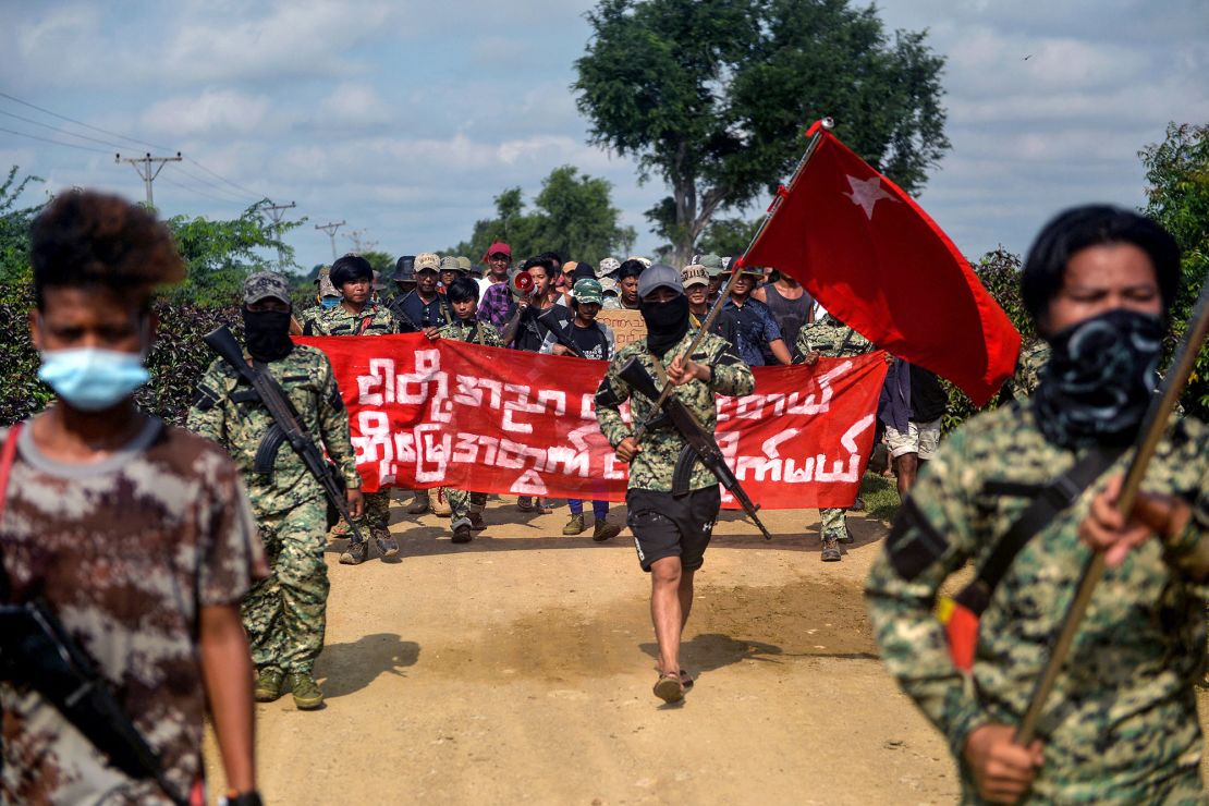 Rebel fighters escort protesters as they take part in a demonstration against the military coup in Sagaing, Myanmar on September 7, 2022.
