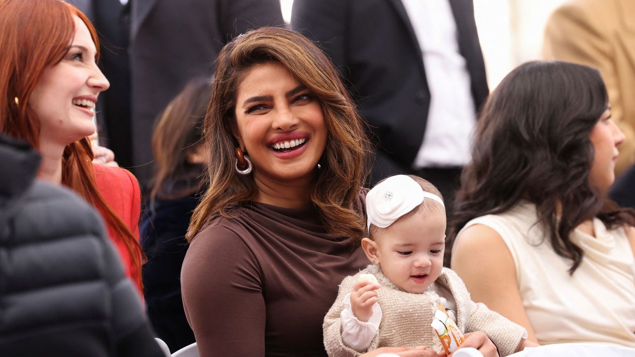 Priyanka Chopra holds her and Nick Jonas' daughter, Malti, during the ceremony on Monday.