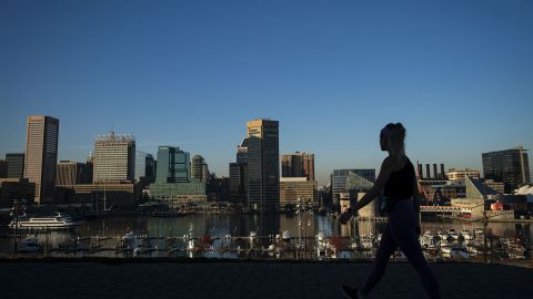 A pedestrian walks past the downtown Baltimore skyline in Federal Hill park in Baltimore, Maryland, U.S., on Friday, Nov. 20, 2020. 