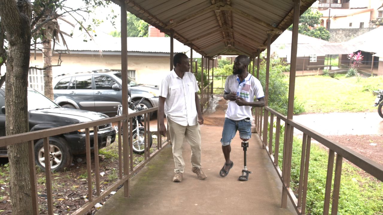 Samai (left) meets SLASA player Maxwell Fornah at the Sierra Leone National Rehabilitation Centre.