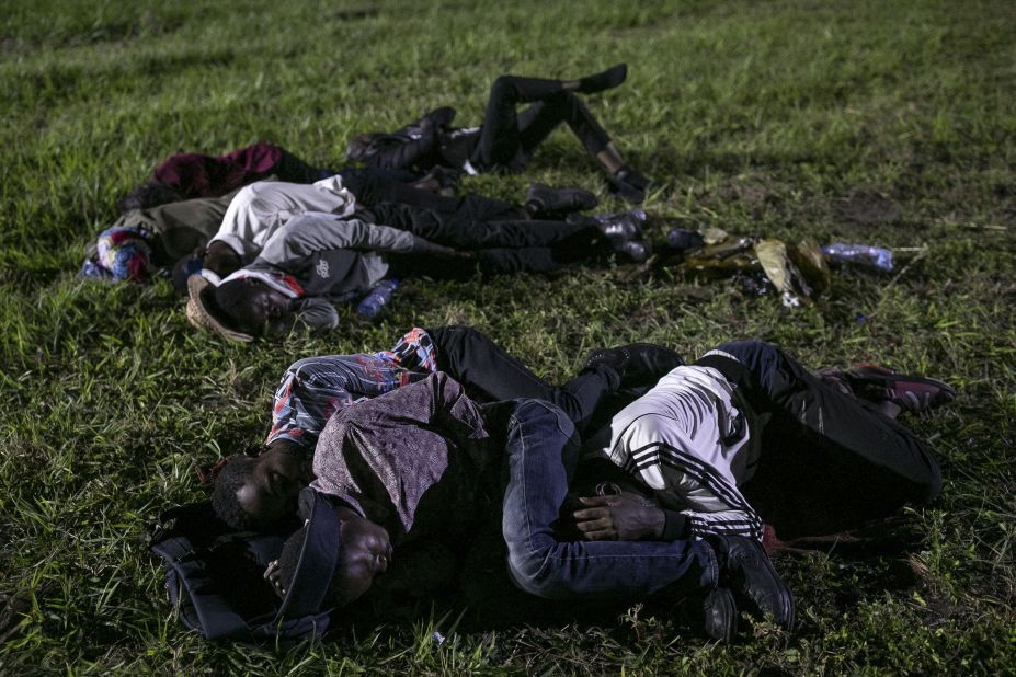 People sleep on the grass ahead of Pope Francis' arrival at N'Dolo Airport in Kinshasa.
