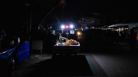 Vendors sell fruit under lights lit by batteries in Lahore, Pakistan, on Jan. 23. Millions of people across Pakistan were plunged into a blackout prompted by a power grid failure.