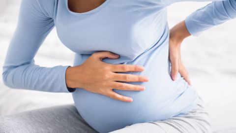 Pregnant woman having abdominal and back aches in the last trimester of pregnancy