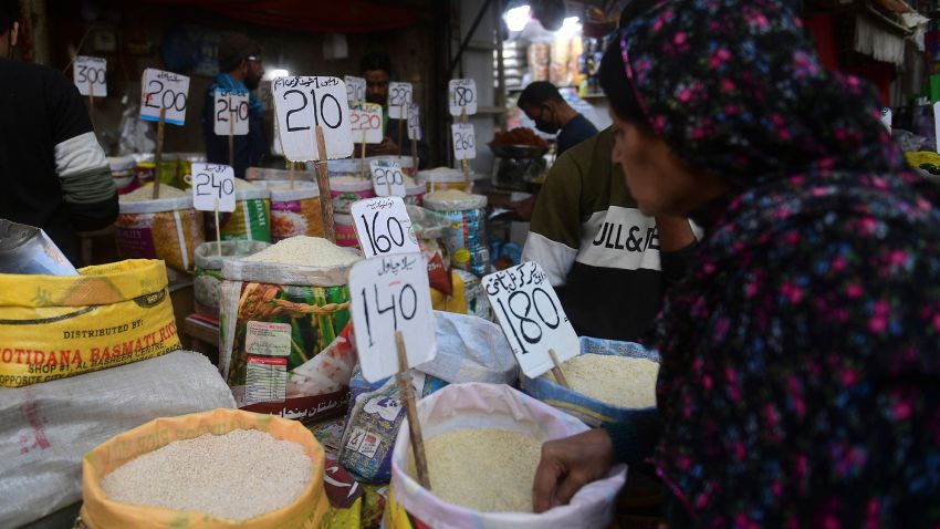 In this picture taken on January 10, 2023, a woman checks rice prices at a main wholesale market in Karachi. 