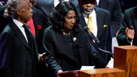 Flanked by the Rev.  Al Sharpton and her husband, Rodney Wells, Row Vaughn Wells speaks during the funeral service for her son Wednesday.