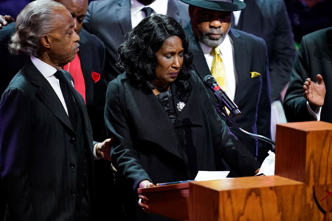 Flanked by the Rev. Al Sharpton and her husband, Rodney Wells, RowVaughn Wells speaks during the funeral service for her son Wednesday.