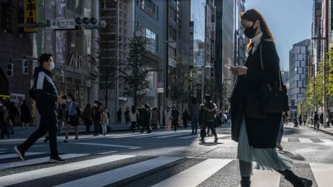 نومبر میں ٹوکیو کے علاقے گنزا میں لوگ ایک سڑک عبور کر رہے ہیں۔  جاپان کی افرادی قوت کی شکل بدل رہی ہے، زیادہ سے زیادہ لوگ پارٹ ٹائم کام کر رہے ہیں۔