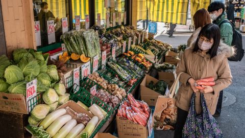 جنوری میں ٹوکیو کی ایک سپر مارکیٹ میں سبزیوں کی تلاش میں صارفین۔  جاپانی وزیر اعظم Fumio Kishida کاروباروں پر زور دے رہے ہیں کہ وہ تنخواہوں میں اضافہ کریں اور محنت کشوں کو زندگی کی بلند قیمتوں کو برقرار رکھنے میں مدد کریں۔