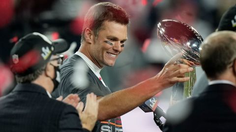 Tampa Bay Buccaneers quarterback Tom Brady looks at the Vince Lombardi trophy after defeating the Kansas City Chiefs in the NFL Super Bowl 55 football game Sunday, Feb. 7, 2021, in Tampa, Fla. The Buccaneers defeated the Chiefs 31-9 to win the Super Bowl. (AP Photo/David J. Phillip)