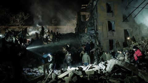 Paramedics traverse rubble for survivors at a destroyed housing complex in downtown Kramatorsk on February 1, 2023.