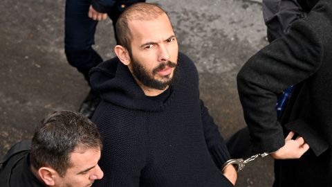 Andrew Tate arrives handcuffed and escorted by police at a courthouse in Bucharest, Romania, on February 1, 2023.