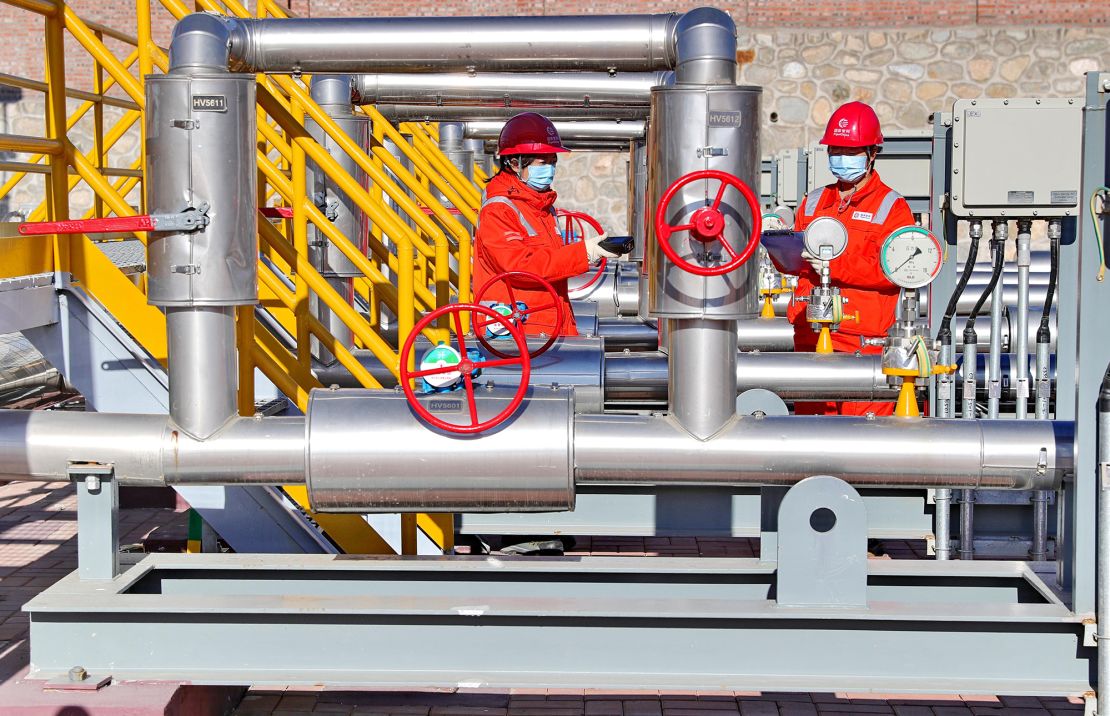 Technicians inspect a natural gas pipeline connected to Russia at a gas-distributing station in northern China's Hebei province in November 2022.