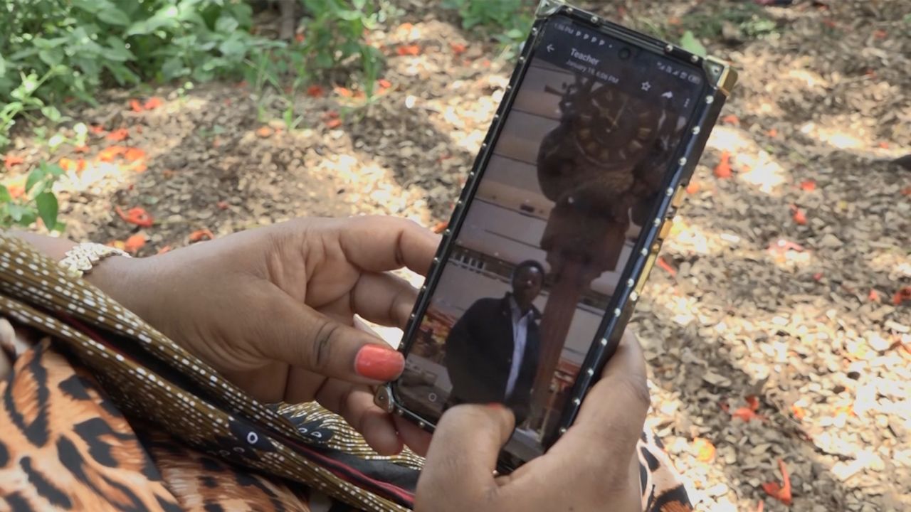 Tanzanian student Nemes Tarimo was killed in Ukraine in October. His cousin, Rehema Makrene Kigoga, looks at a picture of him on her phone.