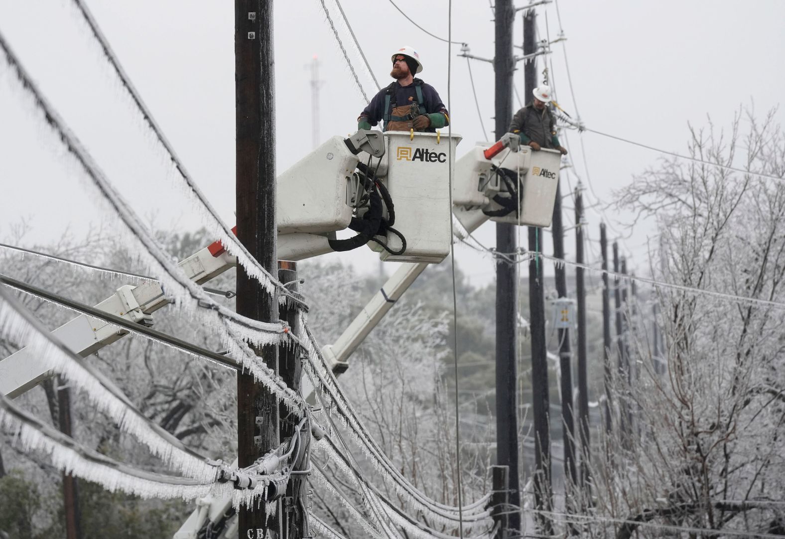Austin Energy workers Ken Gray, left, and Chad Sefcik work to restore power on ice-covered lines in Austin, Texas, on Wednesday, February 1. <a href="index.php?page=&url=https%3A%2F%2Fwww.cnn.com%2F2023%2F02%2F01%2Fweather%2Fwinter-ice-storm-south-central-us-wednesday%2Findex.html" target="_blank">A wave of ice and sleet</a> hammered parts of the southern and central United States.
