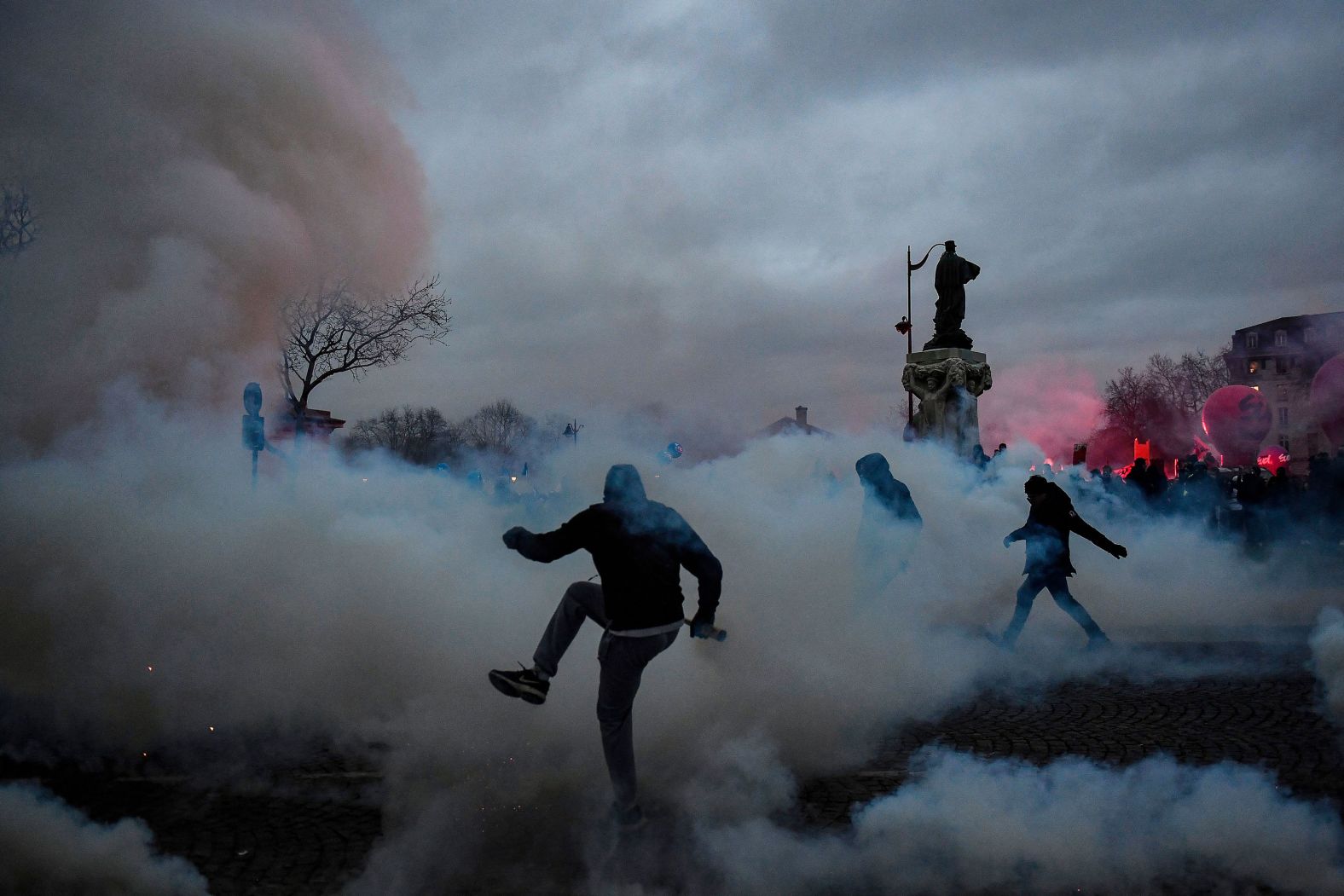 A protester kicks a tear gas canister during clashes with police in Paris on Tuesday, January 31. <a href="index.php?page=&url=https%3A%2F%2Fwww.cnn.com%2F2023%2F01%2F31%2Fbusiness%2Ffrance-strikes-pensions%2Findex.html" target="_blank">Unions staged another mass strike</a> against government plans to raise the retirement age for most workers. French schools and transportation networks were heavily disrupted.