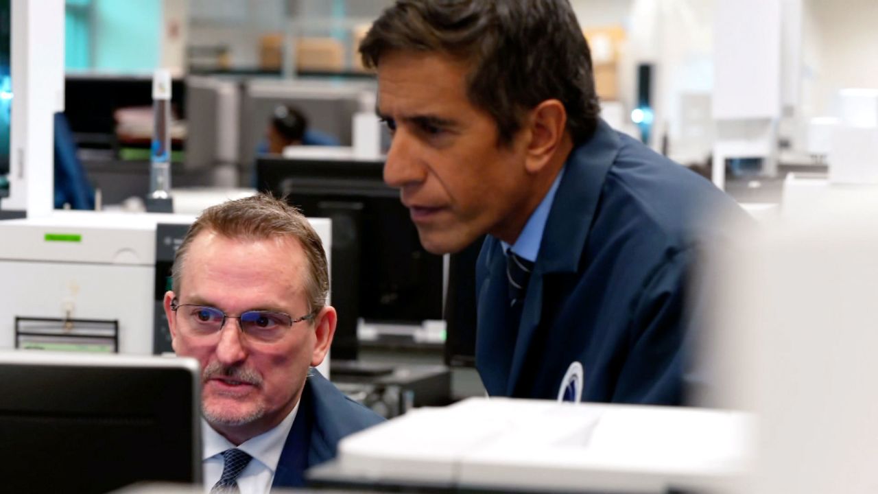 Dr. Sanjay Gupta talks with DEA official Scott Oulton at the drug-testing lab.