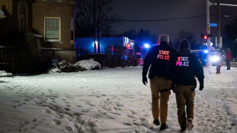 Michigan State Police personnel walk outside a building where multiple bodies were found Thursday.