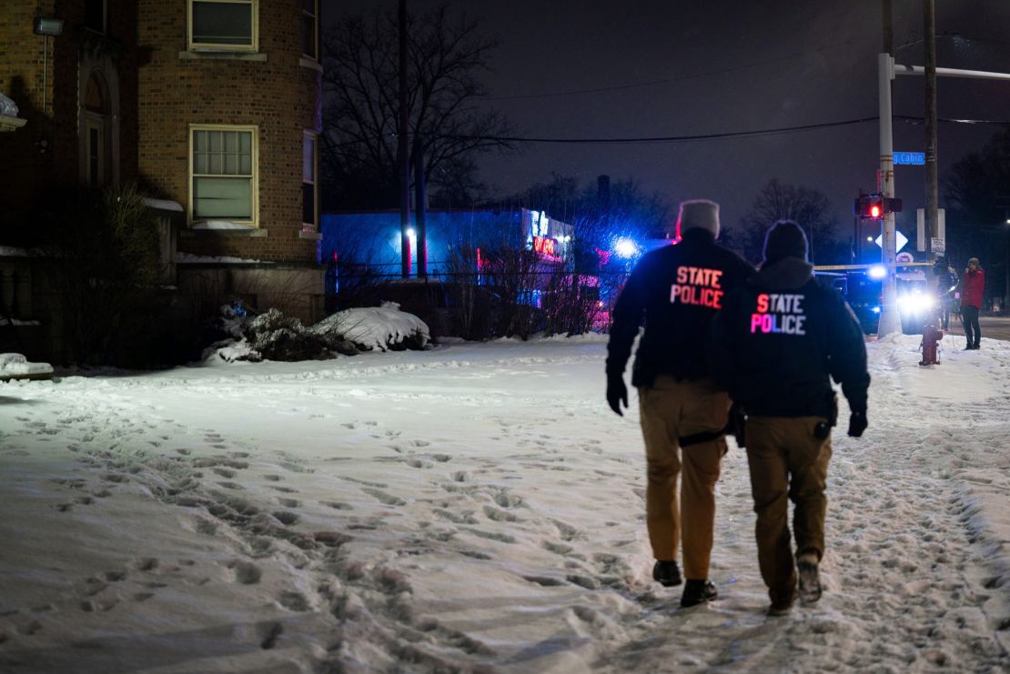 Michigan State Police personnel walk outside a building where bodies were found Thursday.