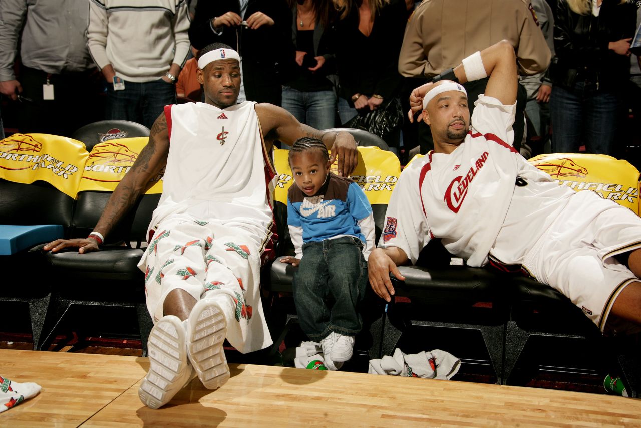 James sits with his young son, Bronny, and teammate Drew Gooden during a game in Cleveland in March 2007.