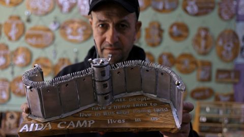 Palestinian Akram al-Waara shows one of his artworks that he made from tear gas canisters and other non-lethal weapons used by Israeli forces against Palestinian demonstrators, in his workshop near the occupied West Bank city of Bethlehem, on Thursday. 