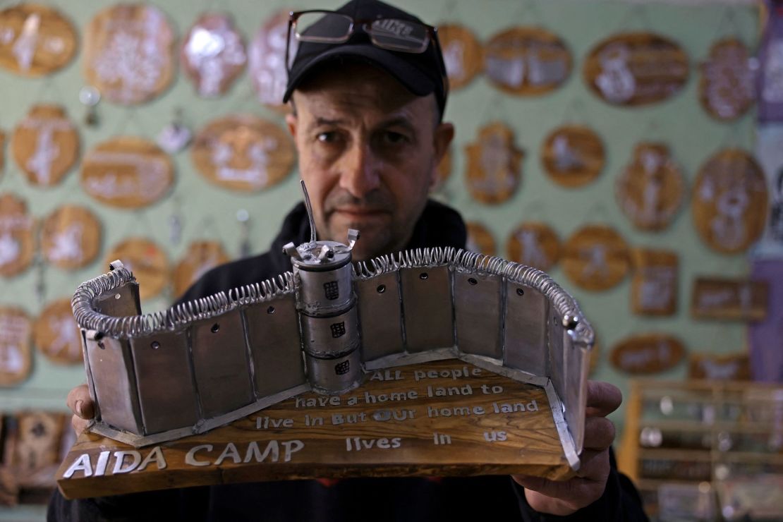 Palestinian Akram al-Waara shows one of his artworks that he made from tear gas canisters and other non-lethal weapons used by Israeli forces against Palestinian demonstrators, in his workshop near the occupied West Bank city of Bethlehem, on Thursday. 