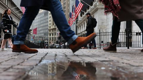 People walk past the New York Stock Exchange (NYSE) during morning trading on January 26, 2023 in New York City. 