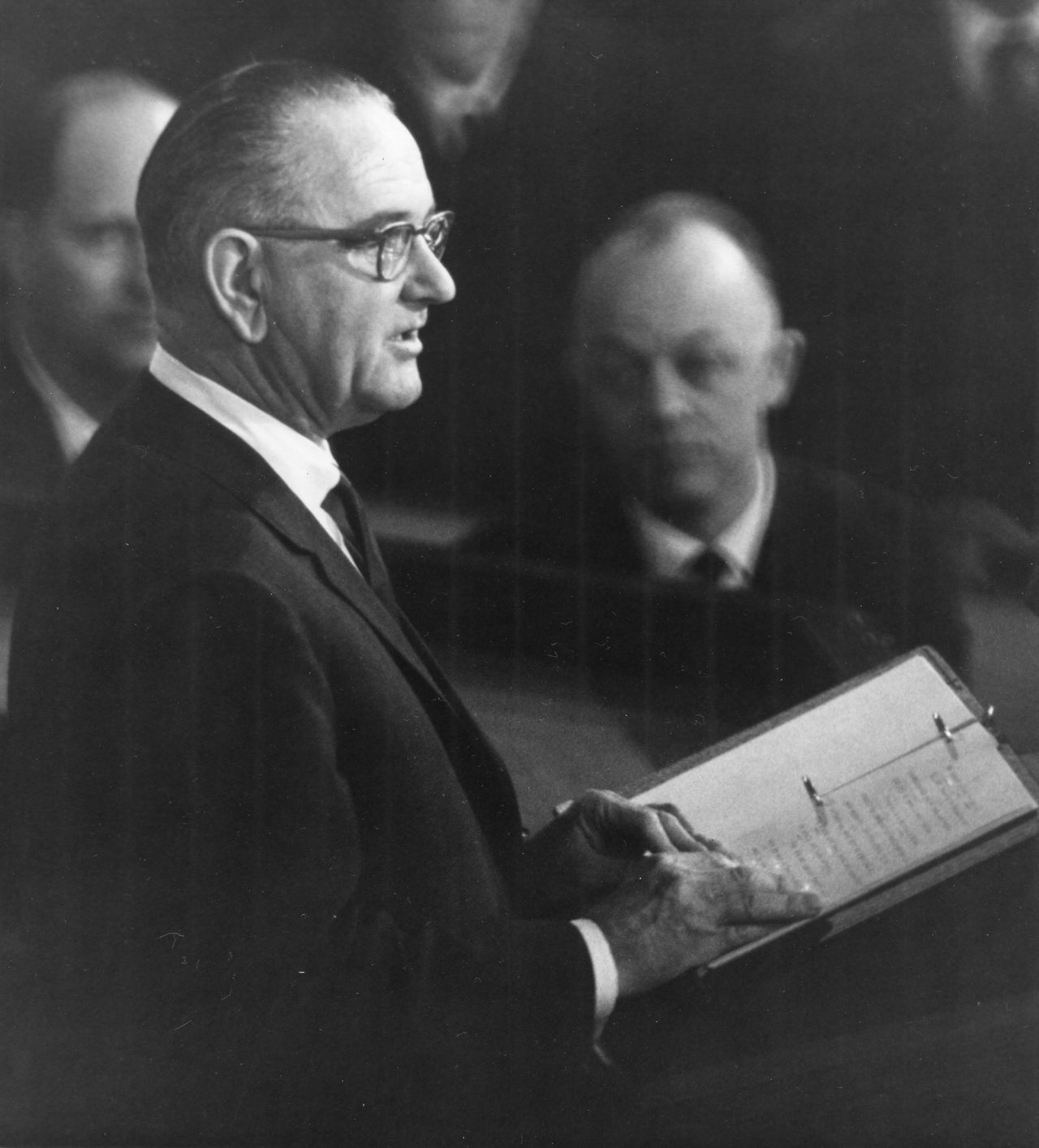 President Lyndon B. Johnson delivers his first State of the Union address in 1964. Sworn in shortly after Kennedy's assassination in November 1963, his first message called on Congress to move forward with Kennedy's plans "not because of our sorrow or sympathy, but because they are right."