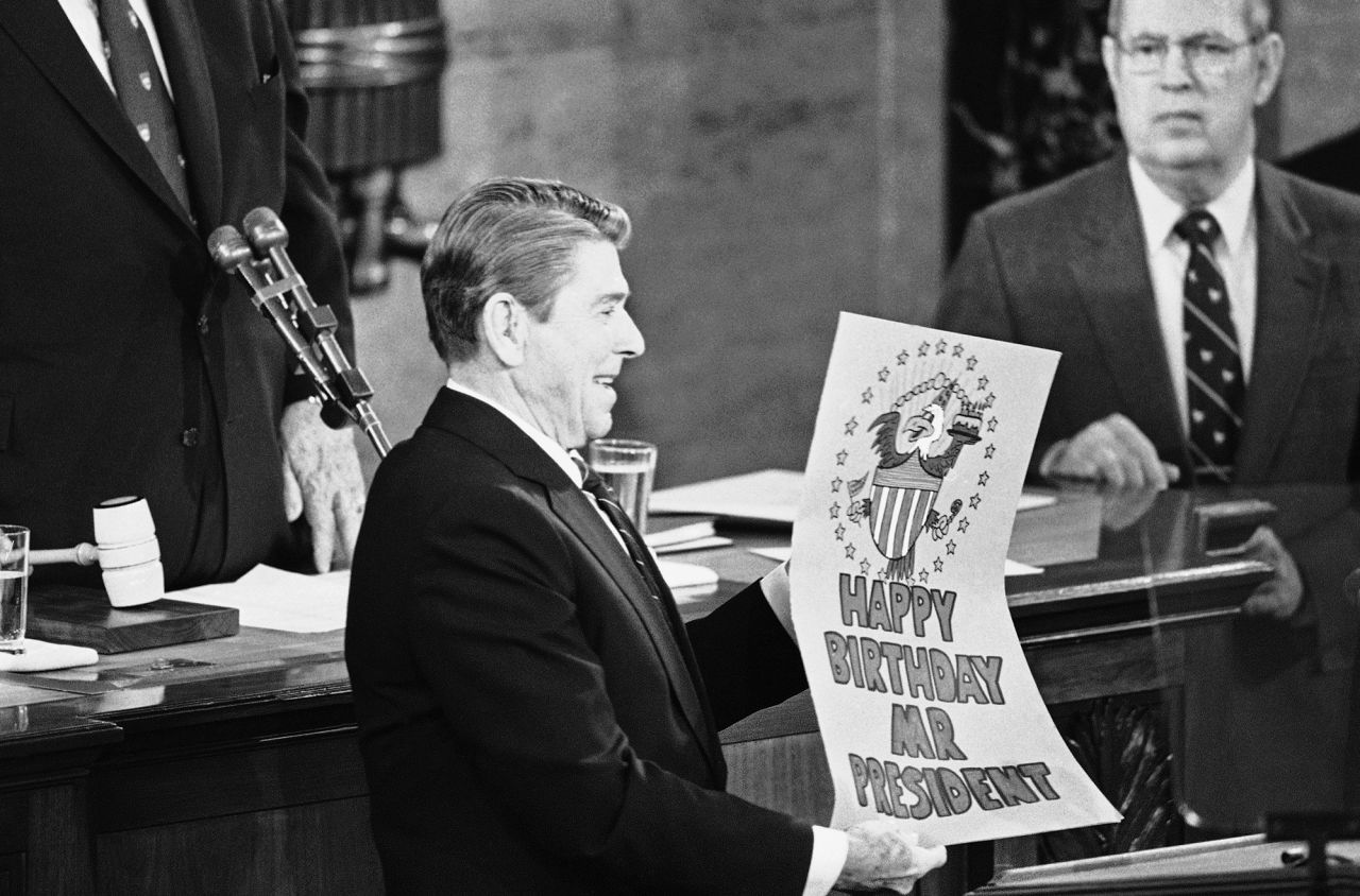 Following his State of the Union speech in 1985, Reagan shows off a birthday card given to him by members of Congress. He delivered the speech on his 74th birthday.