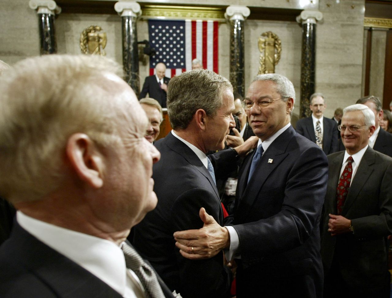 Secretary of State Colin Powell embraces President George W. Bush after Bush's annual address in 2002. Bush called North Korea, Iran and Iraq an "axis of evil" in the speech, which came four months after the 9/11 attacks. It was the first address streamed live online. 