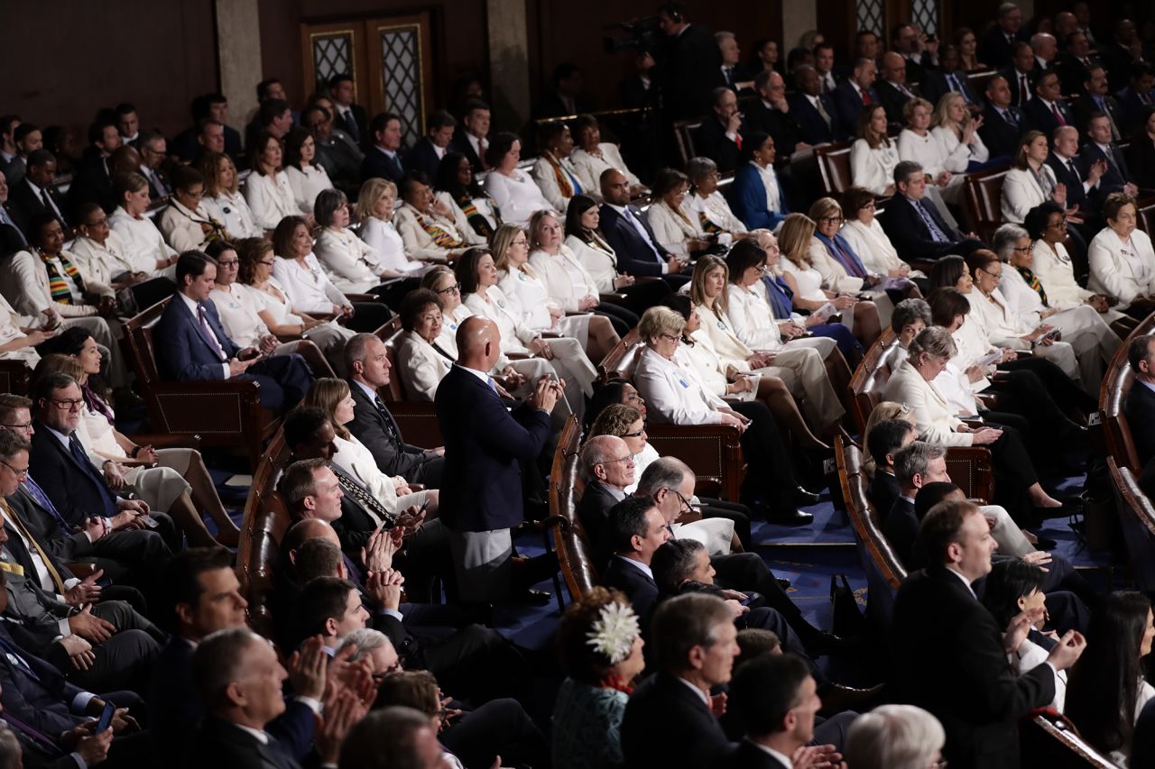Democratic congresswomen dressed in white listen as Trump gives his State of the Union Address, sending a visual message to the president. The all-white attire celebrated the 100th anniversary of the 19th Amendment.