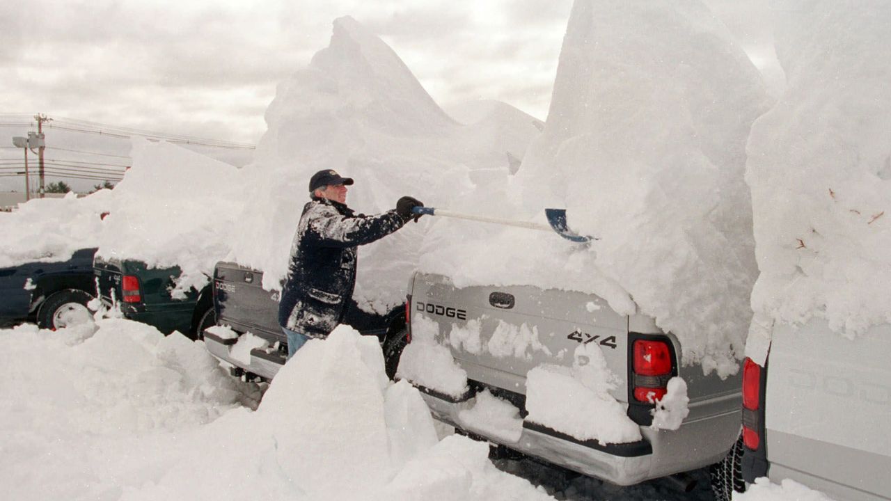 A man clears snow off vehicles after a major nor'easter in 2001 dumped snow across the Northeast.