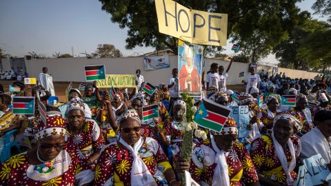 Masyarakat menyambut Paus dengan bendera nasional dan spanduk perdamaian di Katedral St. Theresa di Juba pada hari Sabtu.