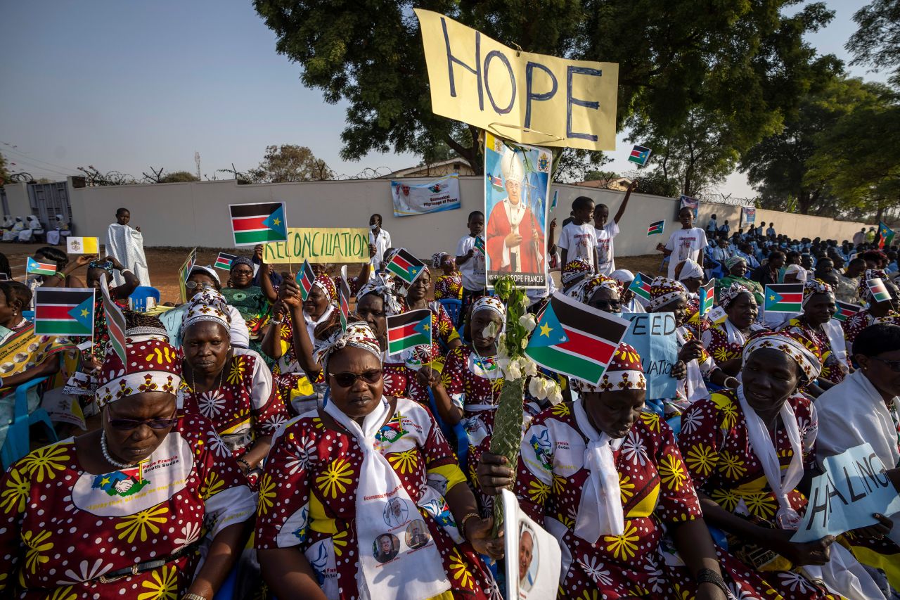 Women holding flags and peace banners await the arrival of Pope Francis at the St. Theresa Cathedral in Juba, South Sudan.