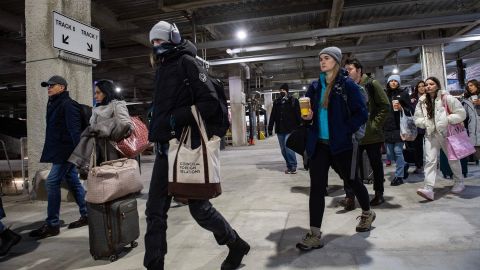 Bundled-up commuters make their way to board a Northeast Regional Amtrak train as temperatures reach minus 7 in Boston, Massachusetts, on February 4, 2023. 