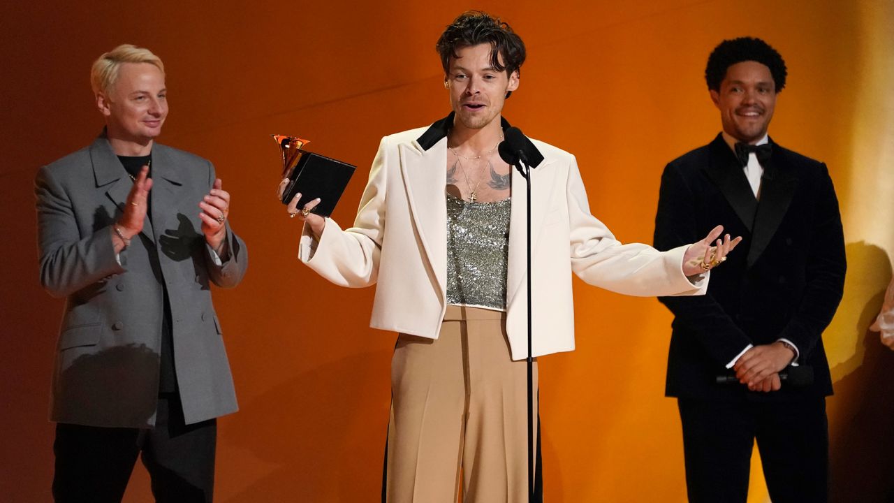 Harry Styles (center) is joined on stage by Kid Harpoon (left) as he accepts the Grammy award for album of the year. But that was just one of the standout moments from the show, which was hosted by Trevor Noah (right). 