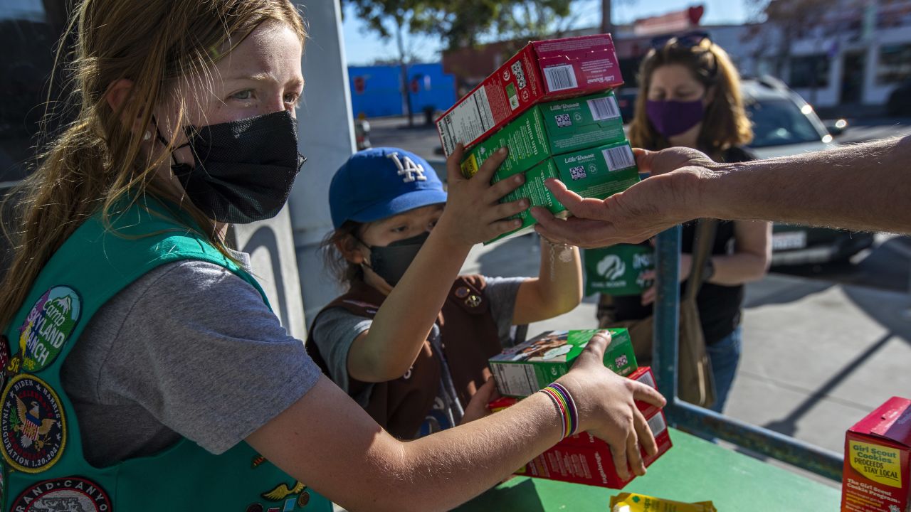 Two young girls sell Girl Scout cookies in Los Angeles on February 11, 2022.
