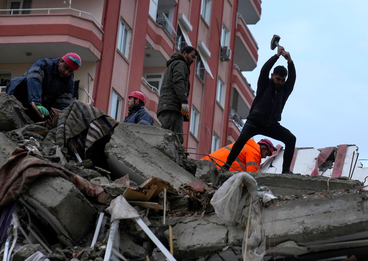People search a destroyed building in Adana, Turkey, on February 6.