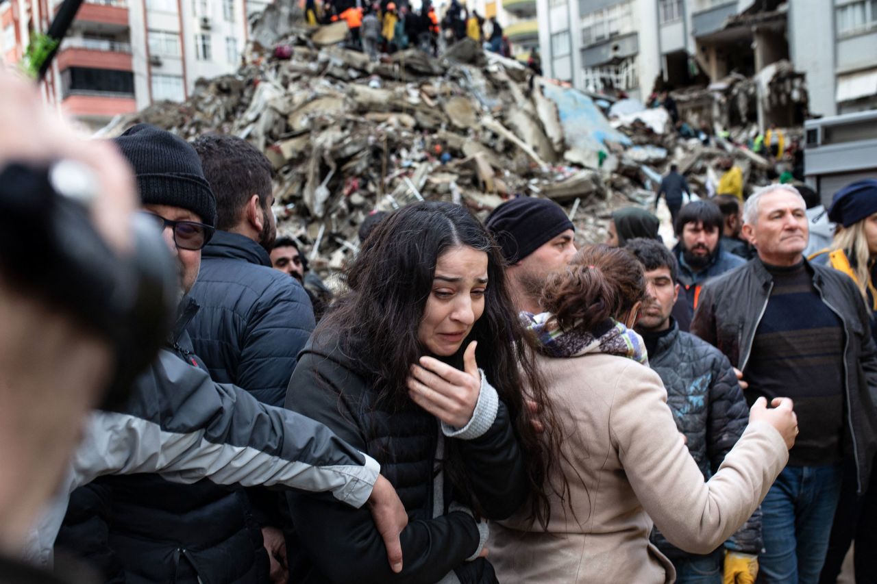 A woman reacts as rescuers search for survivors in Adana.