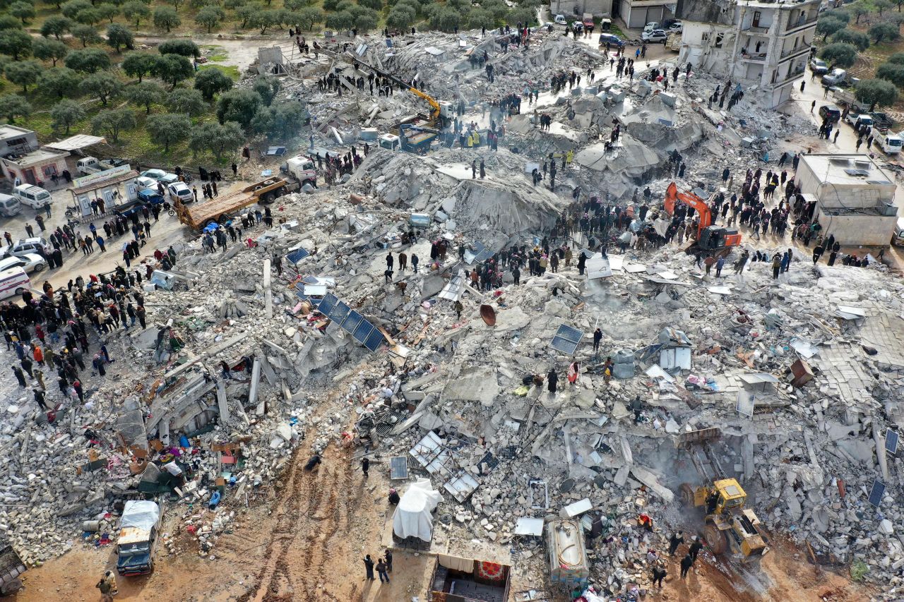 Residents search through collapsed buildings in the Syrian village of Besnia.