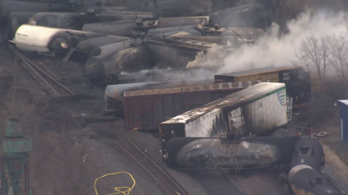 Derailed train cars smoldered Monday in East Palestine, Ohio.