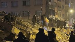 People try to reach trapped residents in a collapsed building in Pazarcik, in Kahramanmaras province, southern Turkey, early Monday, Feb. 6, 2023. A powerful earthquake has caused significant damage in southeast Turkey and Syria and many casualties are feared. Damage was reported across several Turkish provinces, and rescue teams were being sent from around the country. (Depo Photos via AP)