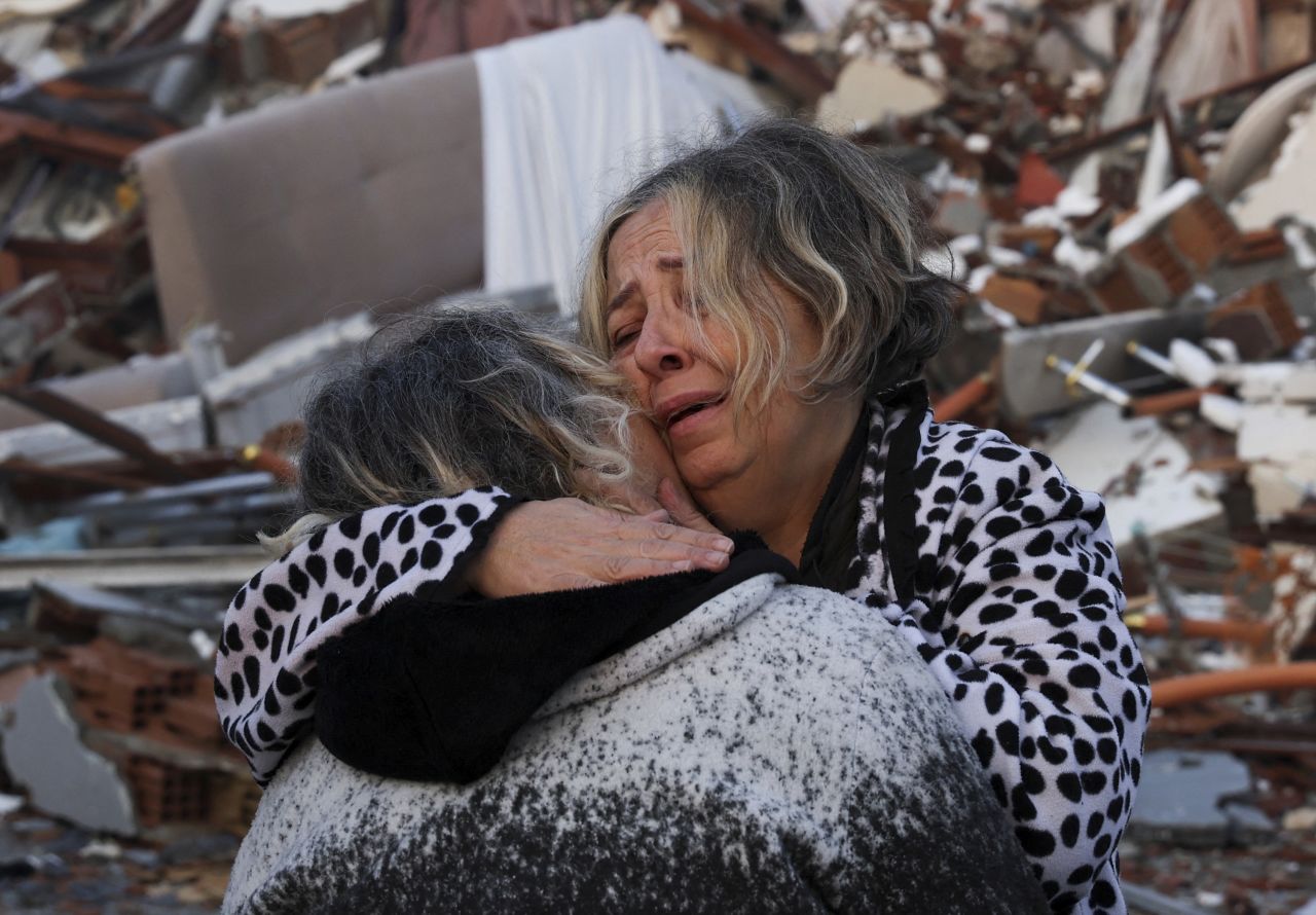 Two people embrace near the rubble of a collapsed building in Hatay on February 7.