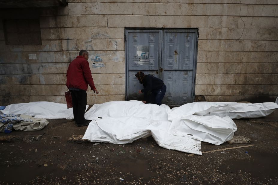 People try to identify the bodies of victims outside a hospital in Aleppo on Monday, February 6.